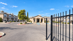 El Paso townhouse for rent - A parking lot in front of a building with a black fence on the right side.