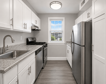 Gaithersburg apartment for rent - A kitchen with white cabinets and a stainless steel refrigerator.