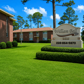 Gulfport apartment for rent - A sign for William Bell stands in front of a building and trees.