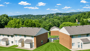 Staunton townhouse for rent - A group of houses with a green lawn in front.