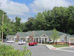 Lumberton apartment for rent - a row of houses with cars parked in a parking lot