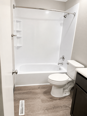 Leavenworth apartment for rent - A white toilet sits next to a bathtub in a bathroom.