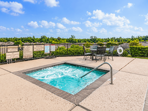 Conroe apartment for rent - A hot tub sits in the middle of a patio surrounded by a fence.