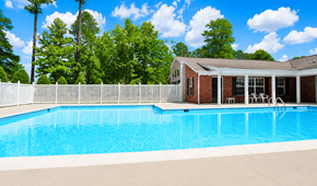 Richmond apartment for rent - A pool in front of a house with trees in the background.