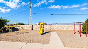 Anthony townhouse for rent - A playground with a yellow slide and red swings.