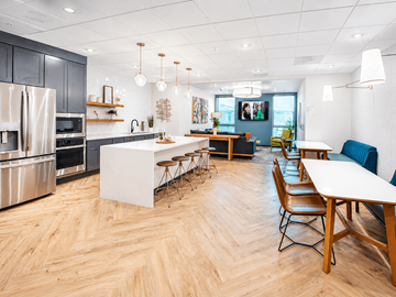 Denver apartment for rent - A modern kitchen with wooden floors and a dining table with chairs.