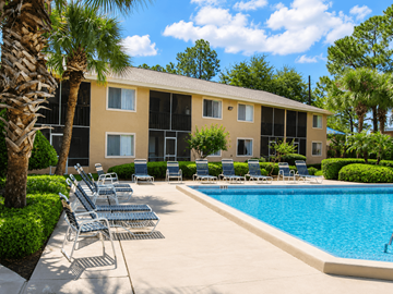Jacksonville apartment for rent - A pool area with chairs and a building in the background.