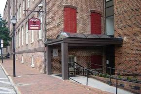 Petersburg apartment for rent - an old brick building with a black awning on the sidewalk