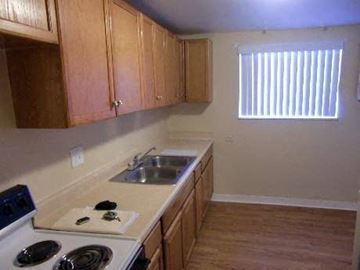 Lakewood apartment for rent - A kitchen with wooden cabinets and a white stove top.