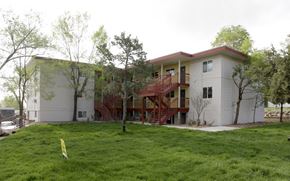 Lakewood apartment for rent - an apartment building with a green lawn and trees