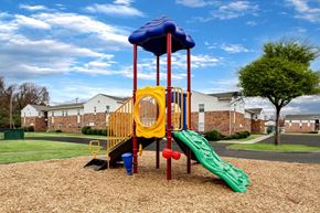 Hampton apartment for rent - A playground with a yellow slide and a blue canopy.