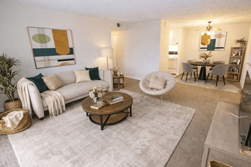 Hermitage apartment for rent - A living room with a white couch, a coffee table, and a painting on the wall.