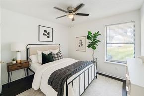 Rogers apartment for rent - A bedroom with a bed, a ceiling fan, and a window with blinds.
