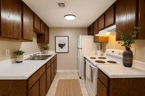 Rogers apartment for rent - A kitchen with brown cabinets and white appliances.