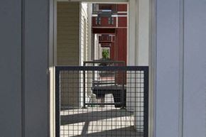 Denver apartment for rent - a view of a balcony with a black dog in front of a door