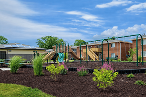 Springfield townhouse for rent - A playground with a slide and a green railing is in front of a building.