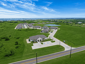 Rockport apartment for rent - A road with a sidewalk and a grassy area with houses in the background.