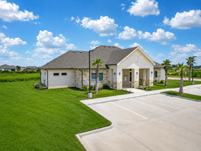 Rockport apartment for rent - A house with a grey roof and white walls is surrounded by a green lawn.
