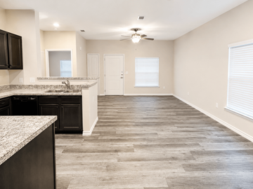 Rockport apartment for rent - A kitchen with black cabinets and a marble countertop.