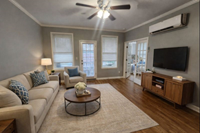 Memphis apartment for rent - A living room with a beige couch, a coffee table, and a flat screen TV mounted on the wall.