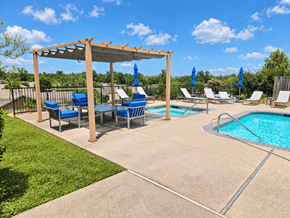 Conroe apartment for rent - A pool area with a pergola and lounge chairs.
