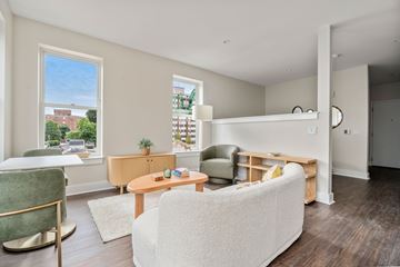 Pawtucket apartment for rent - A living room with a white couch and a green chair.