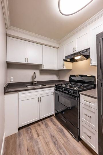 Lowell apartment for rent - a kitchen with black appliances and white cabinets
