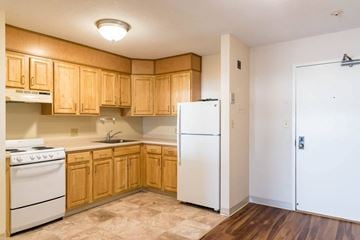 Fall River apartment for rent - A kitchen with wooden cabinets and a white refrigerator.