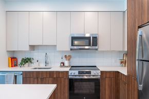 Stoneham apartment for rent - Sleek kitchen at The Devon at Weiss Farm in Stoneham, MA with quartz countertops, wood cabinetry and stainless appliances.