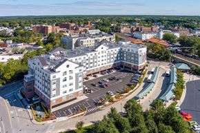 Attleboro apartment for rent - One Wall Street Attleboro Apartments drone view with downtown in background, bus and train station