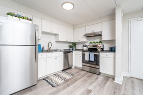 Quincy apartment for rent - a kitchen with white cabinets and stainless steel appliances