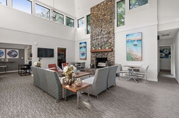 Weymouth apartment for rent - A living room with a stone fireplace and a painting of a beach scene on the wall.