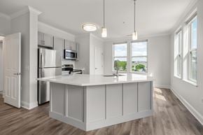 Weymouth apartment for rent - A kitchen with white cabinets and a wooden floor.