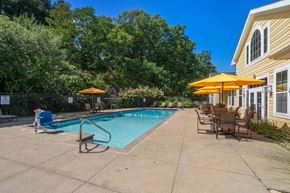 Lynnfield apartment for rent - A pool area with a bench and chairs under umbrellas.