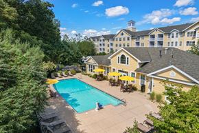 Lynnfield apartment for rent - A large building with a pool in front of it.
