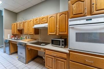 Hingham apartment for rent - a kitchen with wooden cabinets and a stove and a microwave