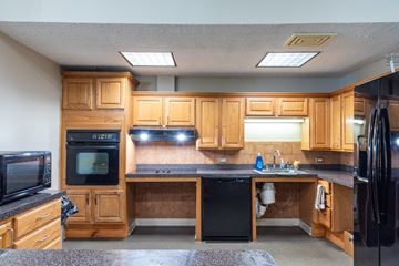 Taunton apartment for rent - A kitchen with wooden cabinets and black appliances.