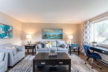 Framingham apartment for rent - A living room with a grey couch, a black coffee table, and a painting on the wall.