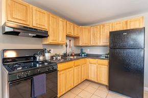 Framingham apartment for rent - a kitchen with black appliances and wooden cabinets