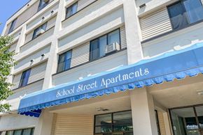 Taunton apartment for rent - A building with a blue awning that says School Street Apartments.