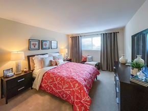 Dracut apartment for rent - A bedroom with a red bedspread and a large bed.