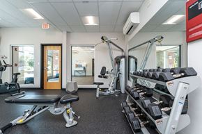 Mansfield apartment for rent - a gym with cardio equipment and weights at one mansfield ave