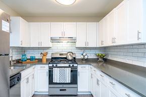 Weymouth apartment for rent - a white kitchen with stainless steel appliances and white cabinets