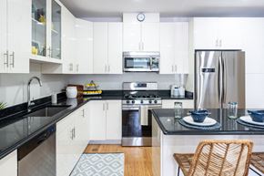 Stoughton apartment for rent - The sto one bedroom kitchen with black granite countertop, gas stove, stainless appliances, and white vibrant cabinetry
