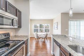 Hanover apartment for rent - A kitchen with granite countertops and a dining area with a table and chairs.