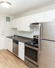 Dorchester apartment for rent - A kitchen with white cabinets and a black fridge.