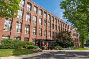Andover apartment for rent - Andover Commons exterior near downtown a large brick building with a sidewalk in front of it