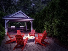 Ashland apartment for rent - A gazebo with red chairs and a fire pit in the middle of a patio.