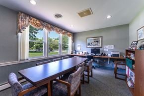 Hanover apartment for rent - A conference room with a long table and chairs, a computer desk, and pictures on the wall.