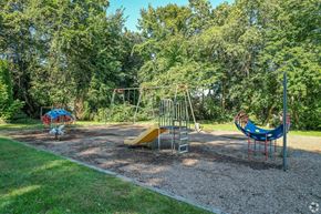 Framingham apartment for rent - A playground with a yellow slide and a blue slide.